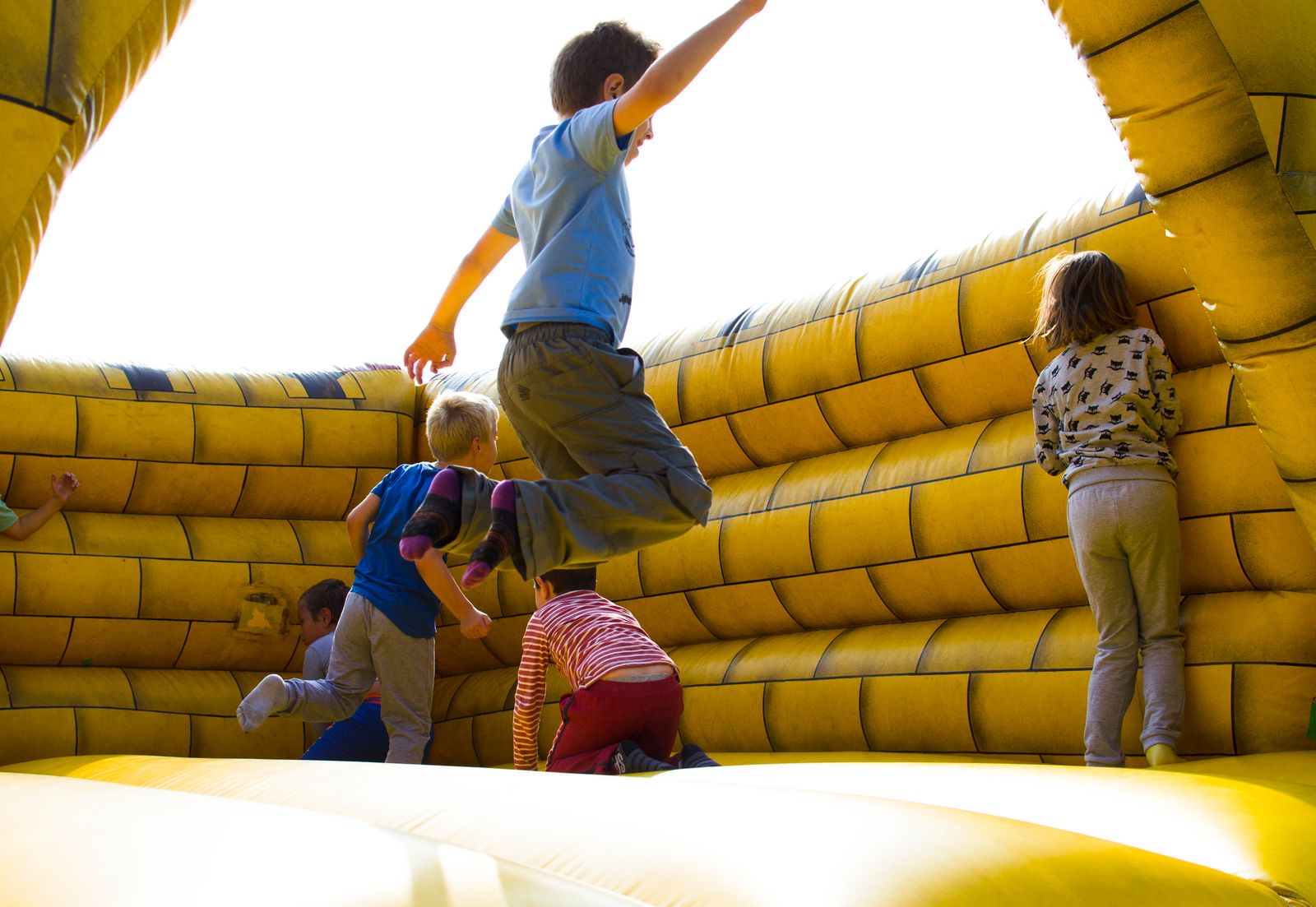 Kids playing on a colorful inflatable bounce castle