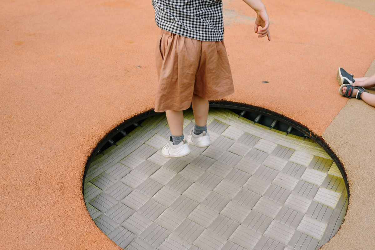Kid mid-jump, having fun outdoors at a party