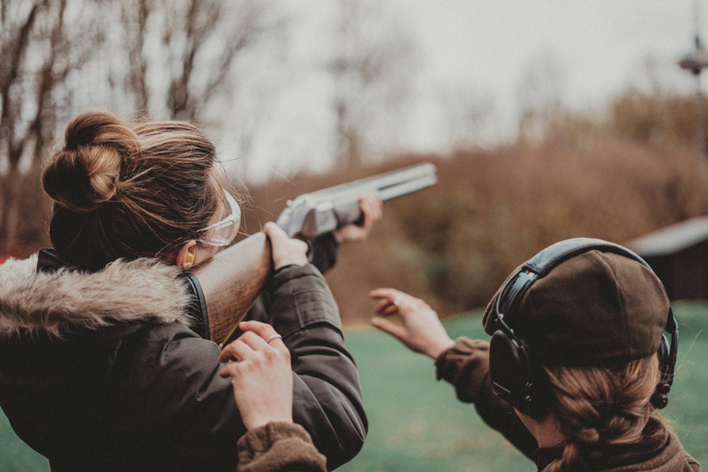 Instructor guiding a student through a shooting stance outdoors