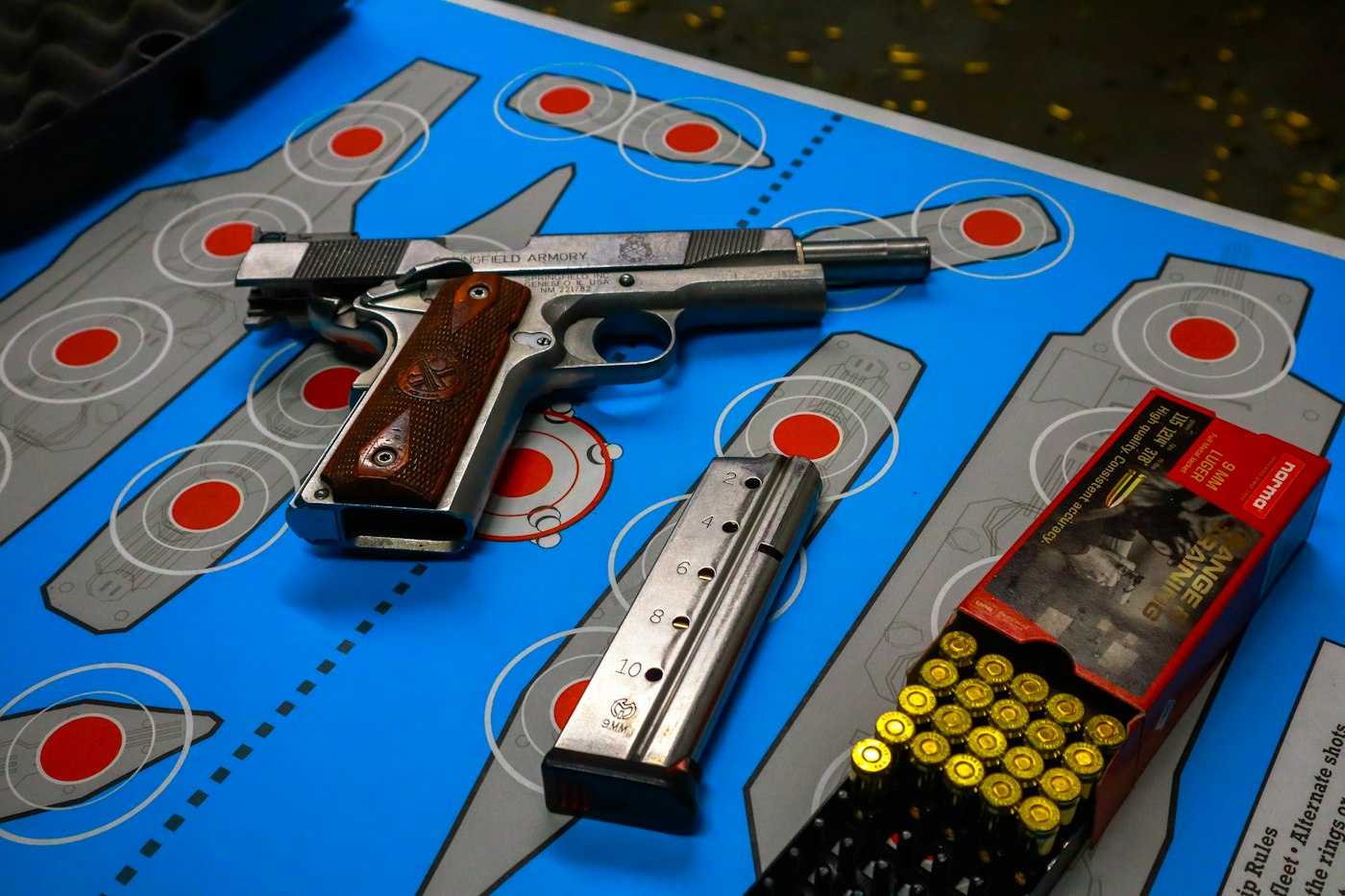 Pistol, magazine, and ammunition laid out on a range mat